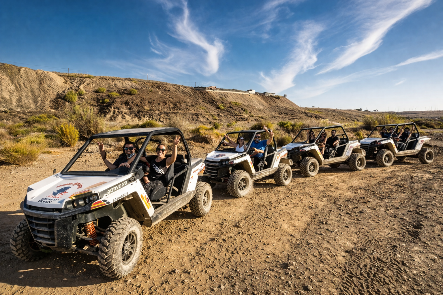 Group of off-road buggies driving across desert landscape in Gran Canaria during guided adventure tour