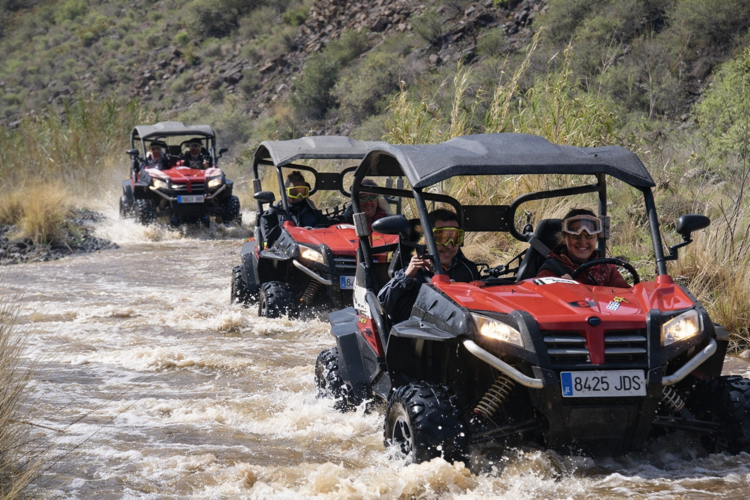 Off-road buggies driving through water and rocky terrain in Gran Canaria during guided adventure tour