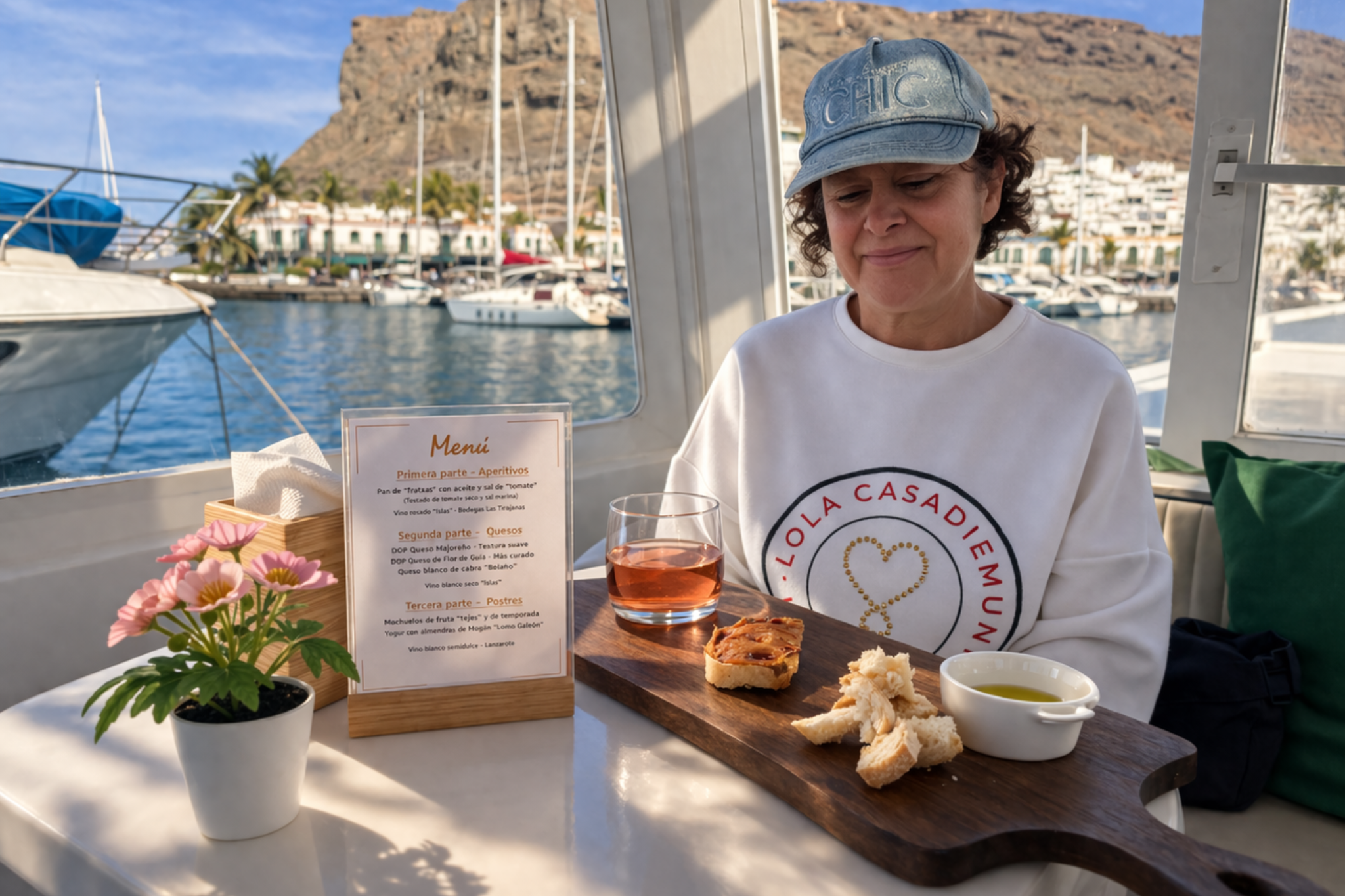 Woman enjoying a local food and wine tasting experience on a boat in Puerto de Mogan, Gran Canaria