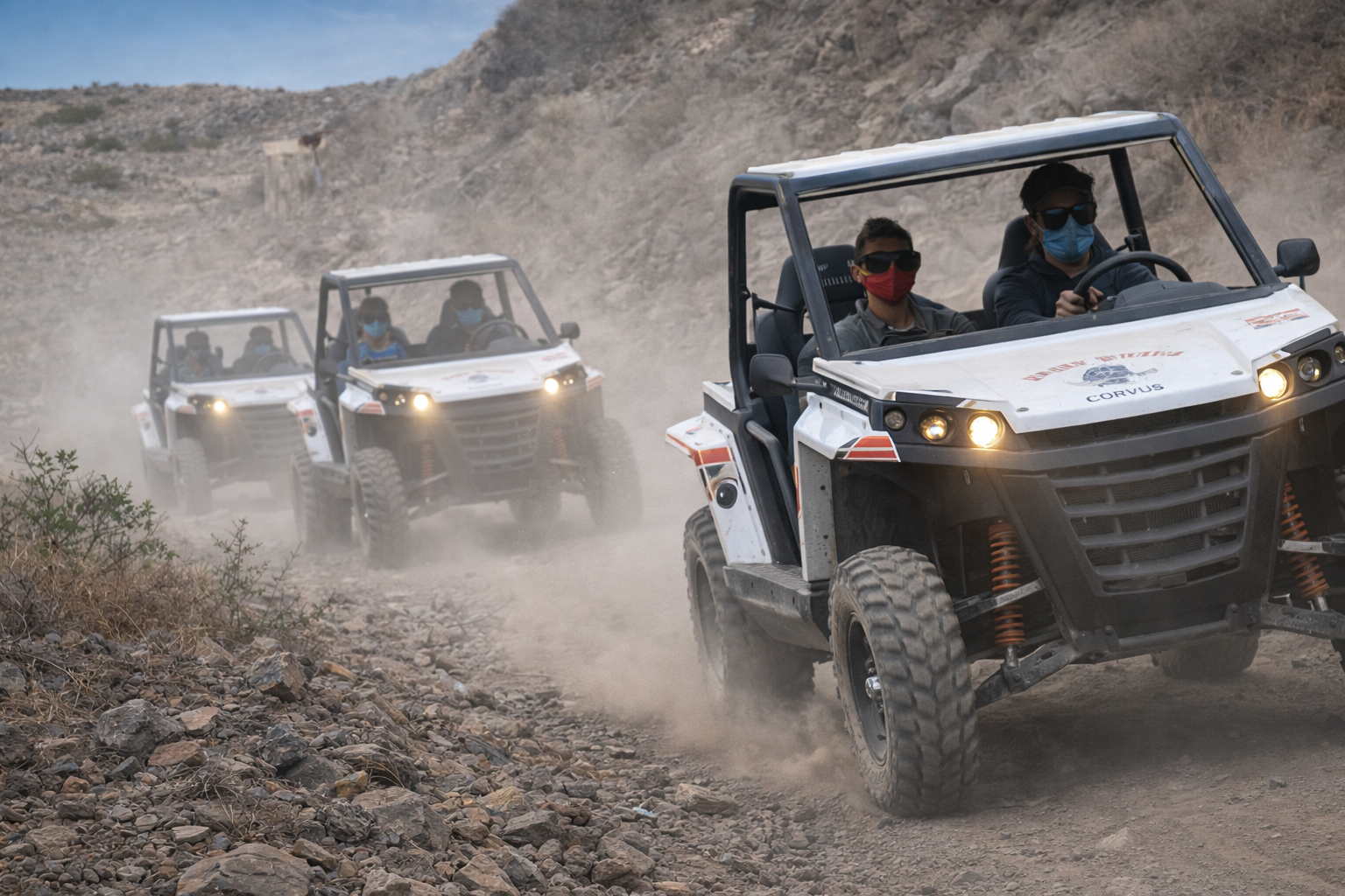 Off-road buggy convoy driving through dusty rocky trail in Gran Canaria during guided adventure tour